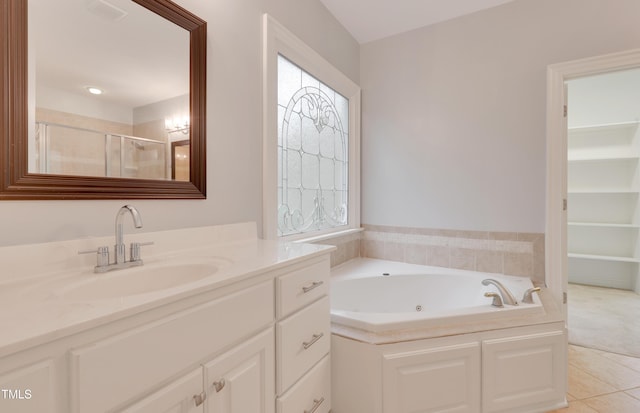 bathroom featuring a stall shower, tile patterned floors, vanity, and a whirlpool tub