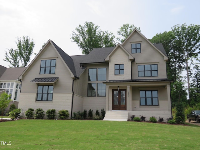 view of front facade featuring brick siding, french doors, and a front yard