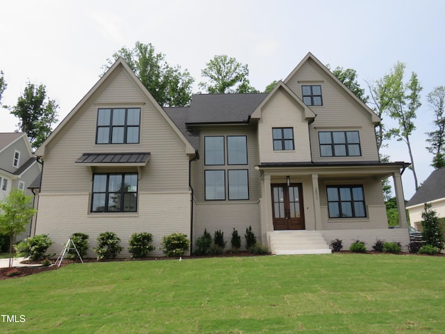 modern farmhouse with brick siding, a front lawn, and french doors