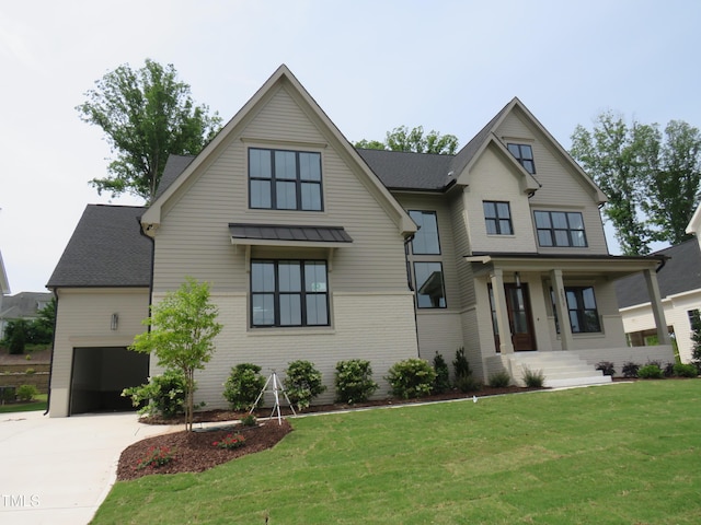 modern farmhouse style home with a porch, concrete driveway, a front lawn, a standing seam roof, and metal roof