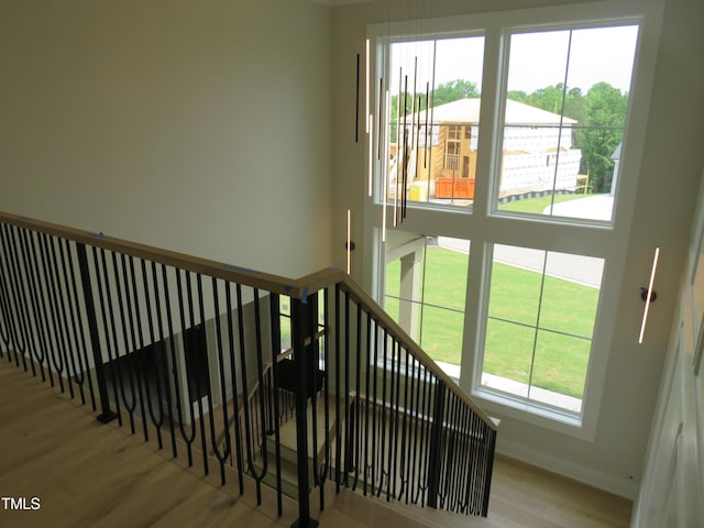 staircase featuring wood finished floors and baseboards