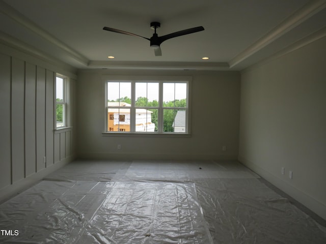 spare room with healthy amount of natural light, a raised ceiling, a ceiling fan, and recessed lighting