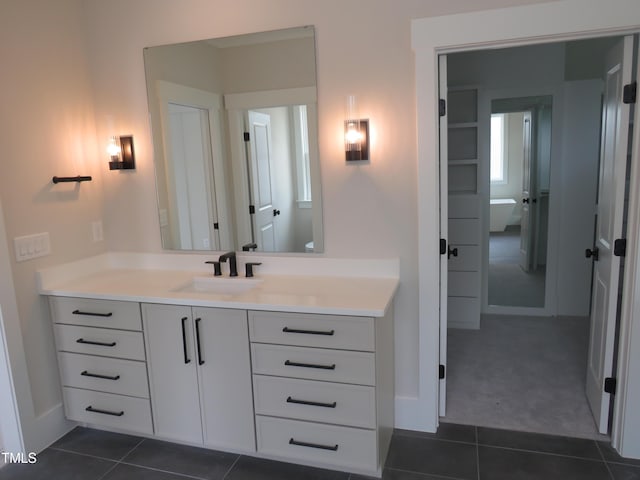 bathroom with tile patterned floors, vanity, and baseboards