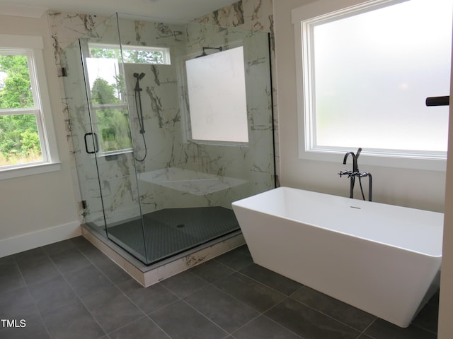 full bath with a marble finish shower, a freestanding tub, tile patterned floors, and baseboards