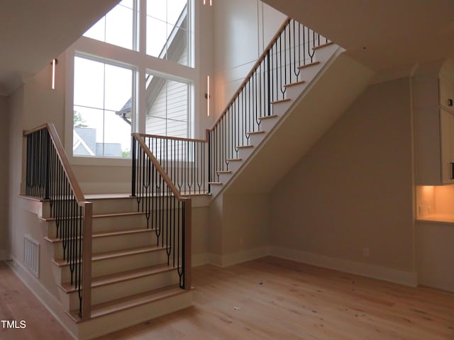 staircase with wood finished floors and baseboards