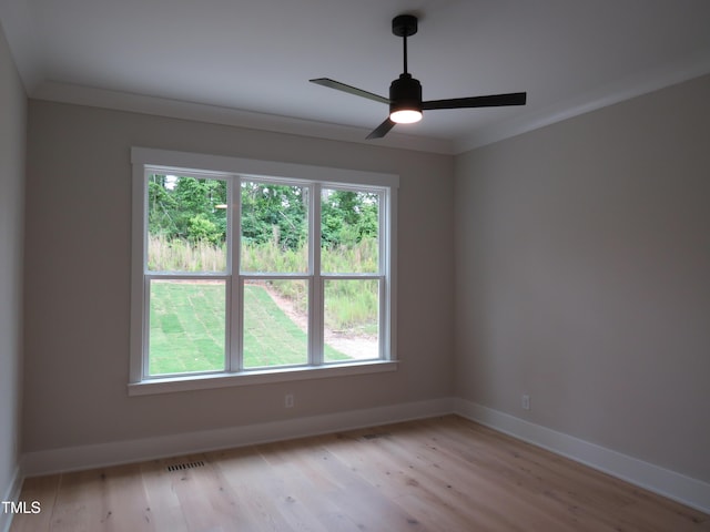 unfurnished room with healthy amount of natural light, baseboards, a ceiling fan, and crown molding