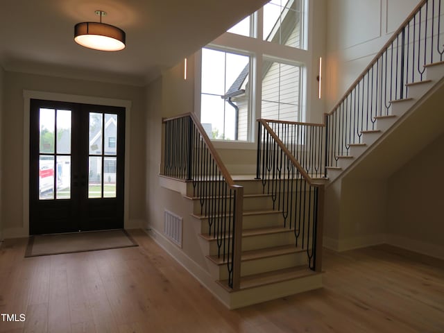 entrance foyer featuring french doors, stairway, wood finished floors, and baseboards