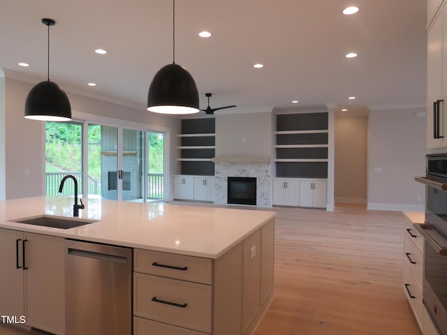 kitchen with a sink, stainless steel appliances, a glass covered fireplace, recessed lighting, and a ceiling fan