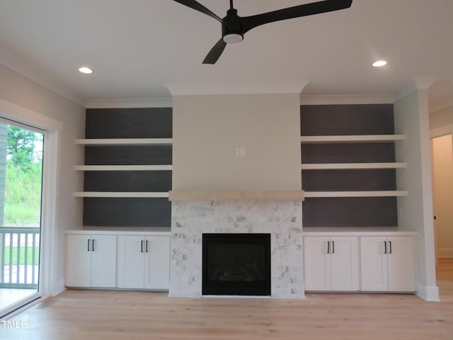 unfurnished living room with light wood-style flooring, a ceiling fan, recessed lighting, ornamental molding, and a glass covered fireplace
