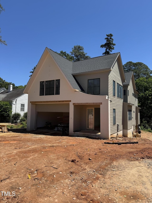 modern inspired farmhouse with roof with shingles, a garage, and driveway