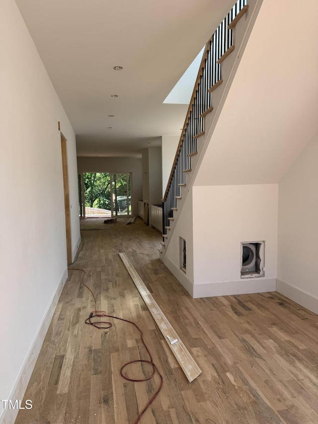 interior space with stairs, baseboards, and wood finished floors