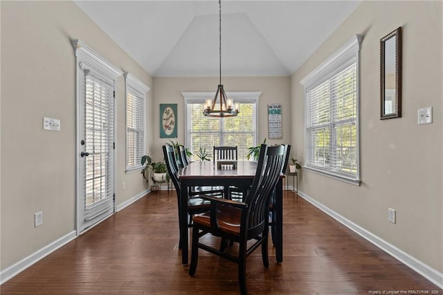 dining area featuring a chandelier, lofted ceiling, baseboards, and dark wood-type flooring