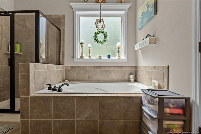 bathroom featuring a stall shower and a bath