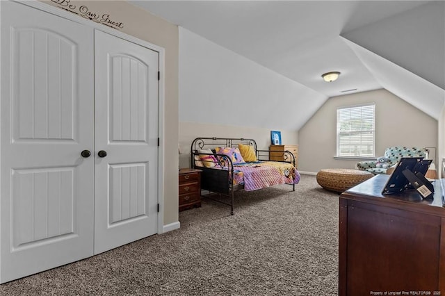 carpeted bedroom with vaulted ceiling and a closet
