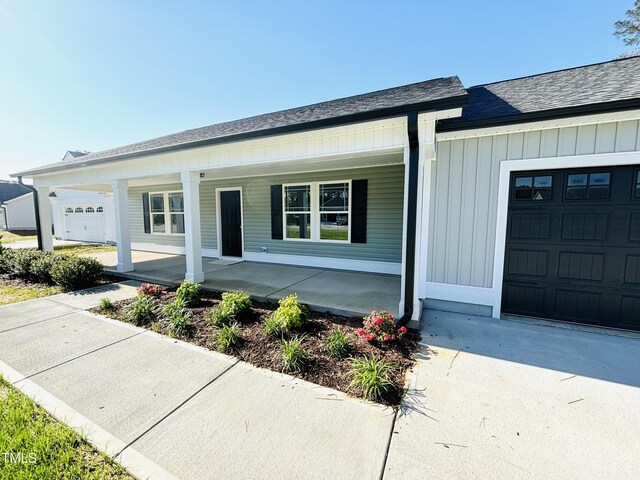 121 Earnest Way, Kenly, NC 27542 - view of front of house featuring covered porch, a shingled roof, and a garage