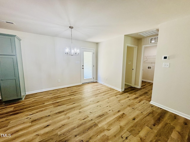 121 Earnest Way, Kenly, NC 27542 - unfurnished dining area with wood finished floors, a chandelier, and baseboards