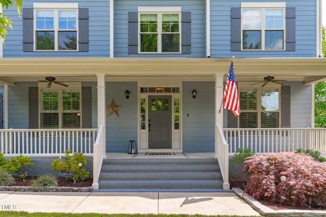 view of exterior entry featuring a ceiling fan and a porch