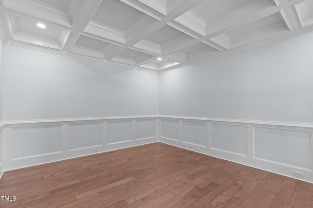 empty room with coffered ceiling, beamed ceiling, recessed lighting, crown molding, and wood finished floors