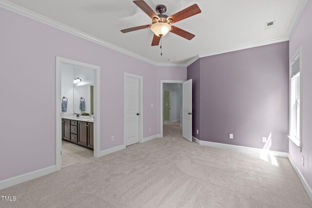 unfurnished bedroom with ornamental molding, light carpet, baseboards, and ensuite bath