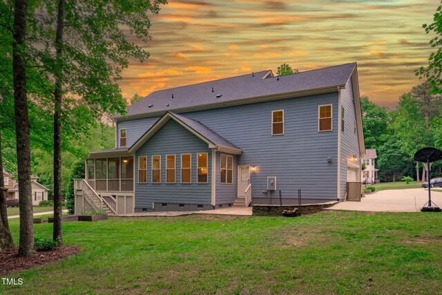 rear view of house featuring a sunroom, stairway, a yard, crawl space, and driveway