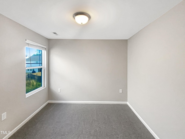 carpeted spare room with visible vents and baseboards