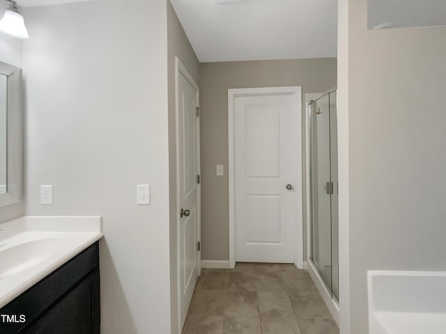 full bath with vanity, baseboards, and a stall shower