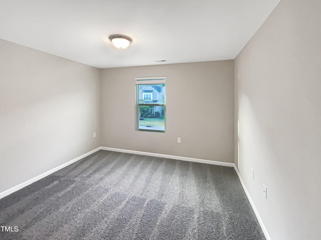 unfurnished room featuring carpet and baseboards