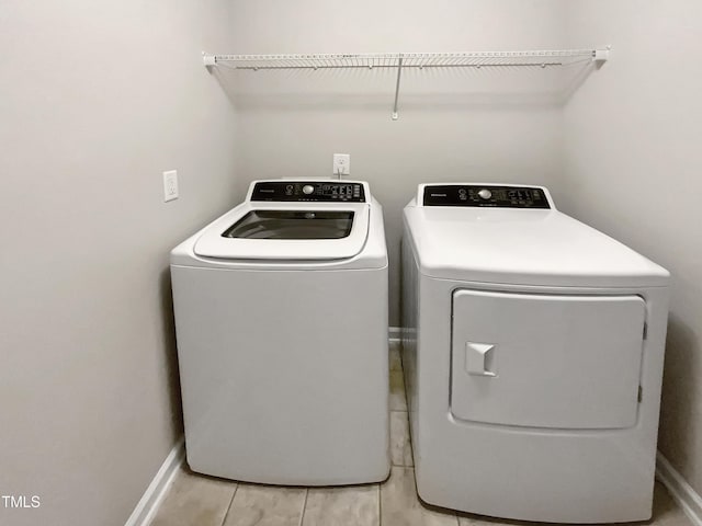 washroom with washer and dryer and baseboards
