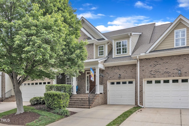 view of front of house featuring a shingled roof, driveway, brick siding, and a garage