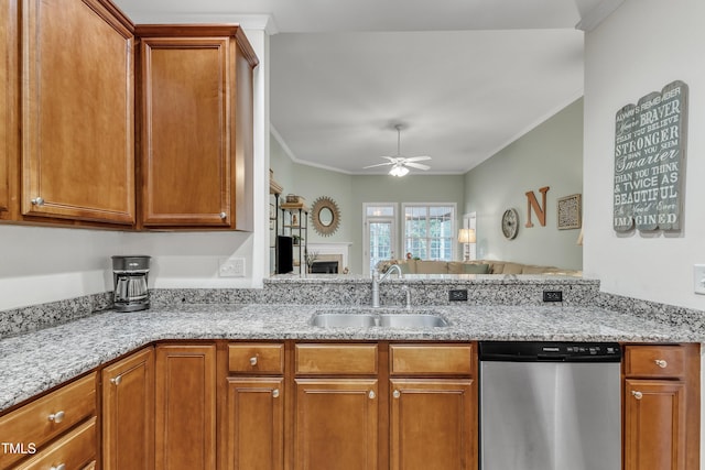 kitchen with stainless steel dishwasher, a sink, ceiling fan, light stone counters, and brown cabinets