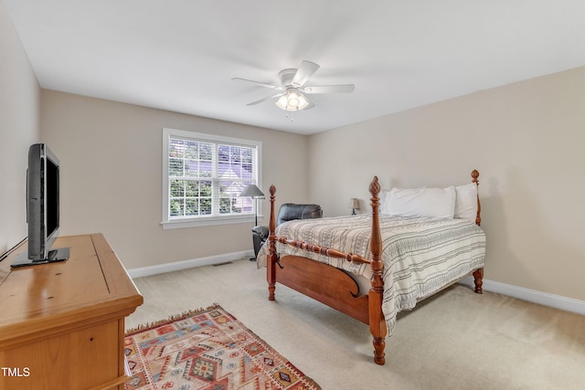 bedroom featuring baseboards, light colored carpet, and ceiling fan