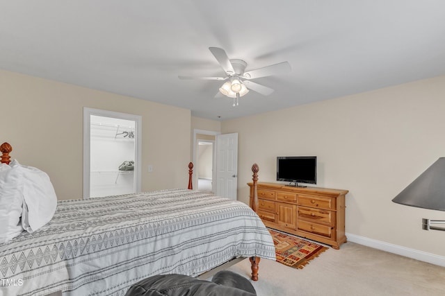 bedroom featuring light colored carpet, baseboards, and a ceiling fan