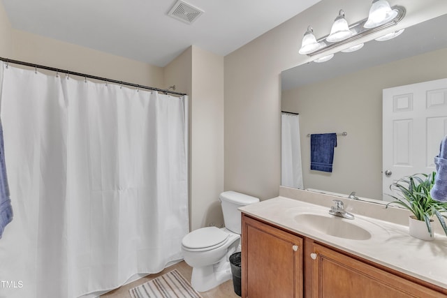 bathroom featuring toilet, vanity, and a shower with shower curtain