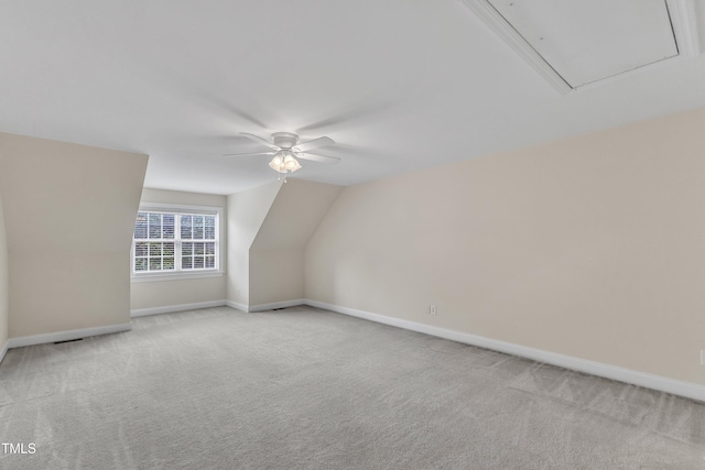 bonus room featuring a ceiling fan, light colored carpet, attic access, baseboards, and lofted ceiling