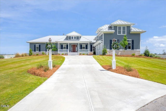 76 Soundside Dr, Oriental, NC 28571 - view of front of home with a standing seam roof, a porch, driveway, a front yard, and metal roof