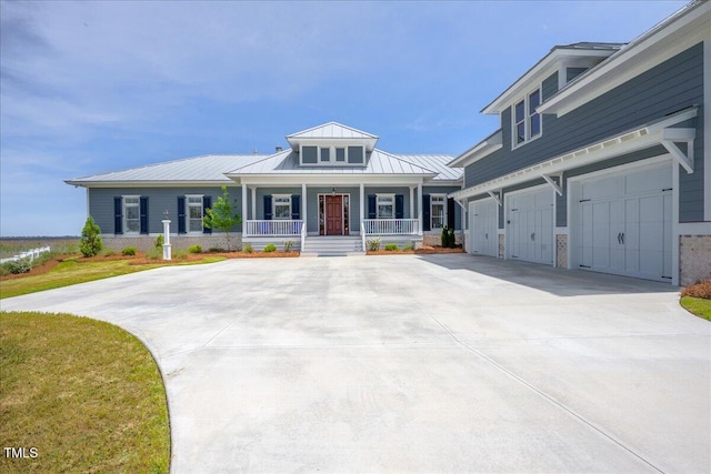 76 Soundside Dr, Oriental, NC 28571 - view of front of house with a porch, driveway, an attached garage, metal roof, and a standing seam roof