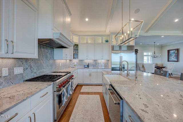 76 Soundside Dr, Oriental, NC 28571 - kitchen with premium appliances, a chandelier, light stone countertops, decorative light fixtures, and white cabinetry