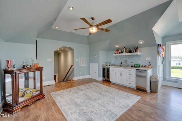 76 Soundside Dr, Oriental, NC 28571 - indoor wet bar with wine cooler, stainless steel dishwasher, vaulted ceiling, ceiling fan, and light wood-style floors
