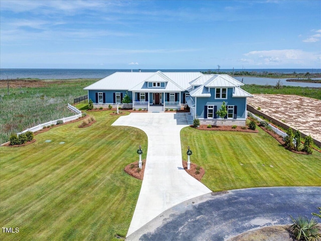 76 Soundside Dr, Oriental, NC 28571 - view of front facade featuring a porch, concrete driveway, a water view, metal roof, and a front yard