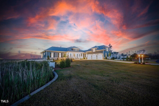 76 Soundside Dr, Oriental, NC 28571 - back of house at dusk with a lawn, an attached garage, metal roof, and a standing seam roof