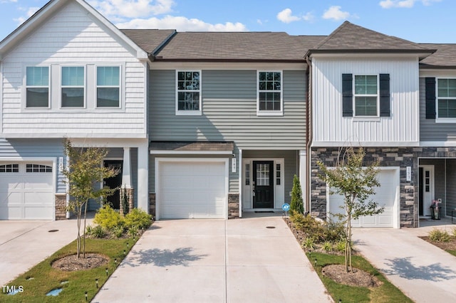 149 E Porthaven Way, Clayton, NC 27527 - townhome / multi-family property featuring stone siding, a shingled roof, driveway, and an attached garage