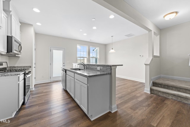149 E Porthaven Way, Clayton, NC 27527 - kitchen with light stone counters, a sink, a center island with sink, stainless steel appliances, and dark wood-style floors