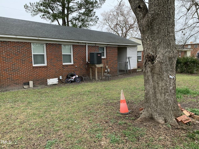 904 Marvin St, Goldsboro, NC 27530 - back of property featuring central air condition unit, a lawn, brick siding, and a shingled roof