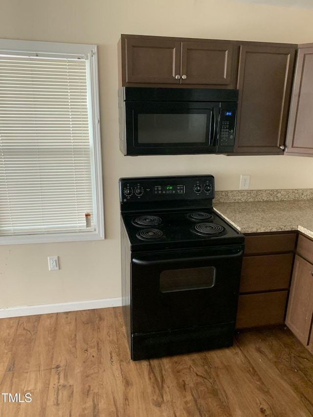 904 Marvin St, Goldsboro, NC 27530 - kitchen featuring black appliances, wood finished floors, light countertops, and dark brown cabinetry