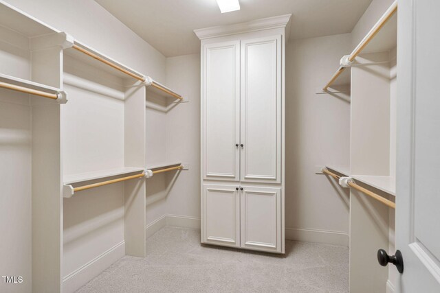walk in closet featuring light colored carpet