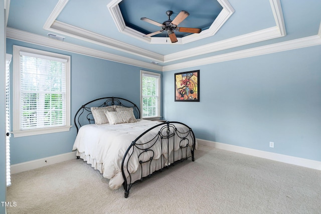 bedroom featuring carpet floors, crown molding, a tray ceiling, and baseboards