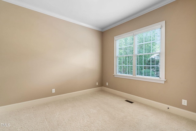 carpeted empty room with ornamental molding and baseboards