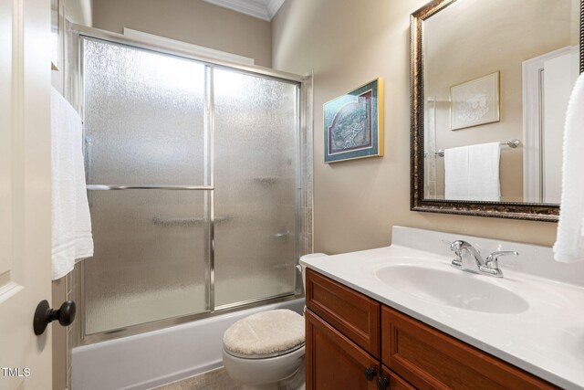 full bath with ornamental molding, vanity, toilet, and enclosed tub / shower combo
