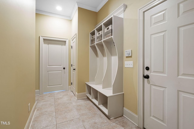 mudroom featuring ornamental molding, baseboards, and light tile patterned flooring