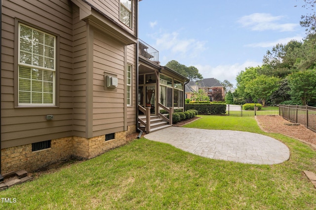 view of yard with a sunroom, a balcony, a patio, and a wall mounted AC